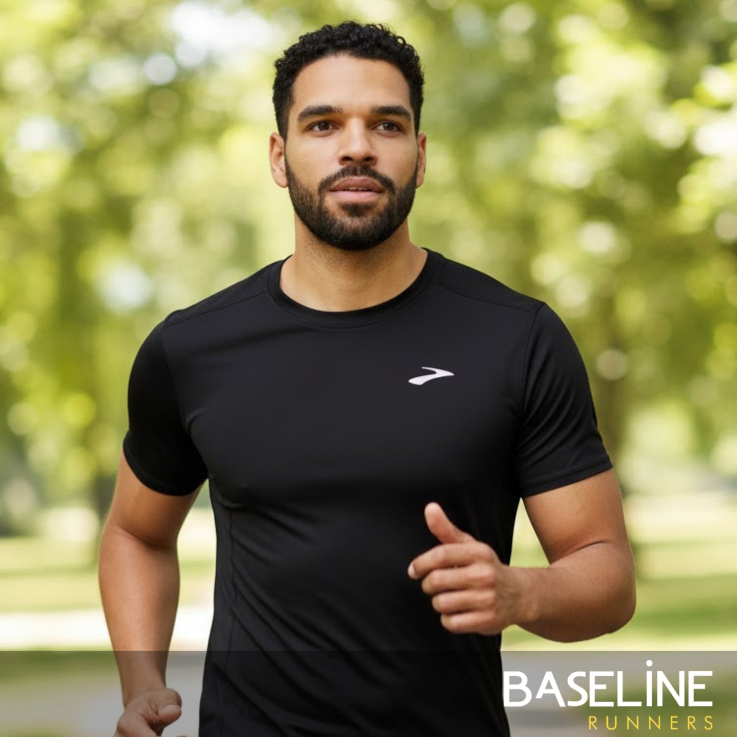 Man wearing a black athletic shirt with a brand logo, running outdoors.