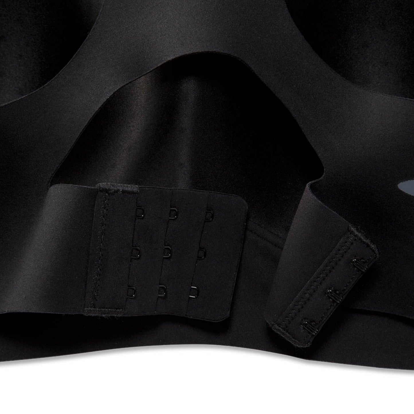Close-up of a black seamless underwire bra showing the adjustable hook-and-eye back closure straps.
