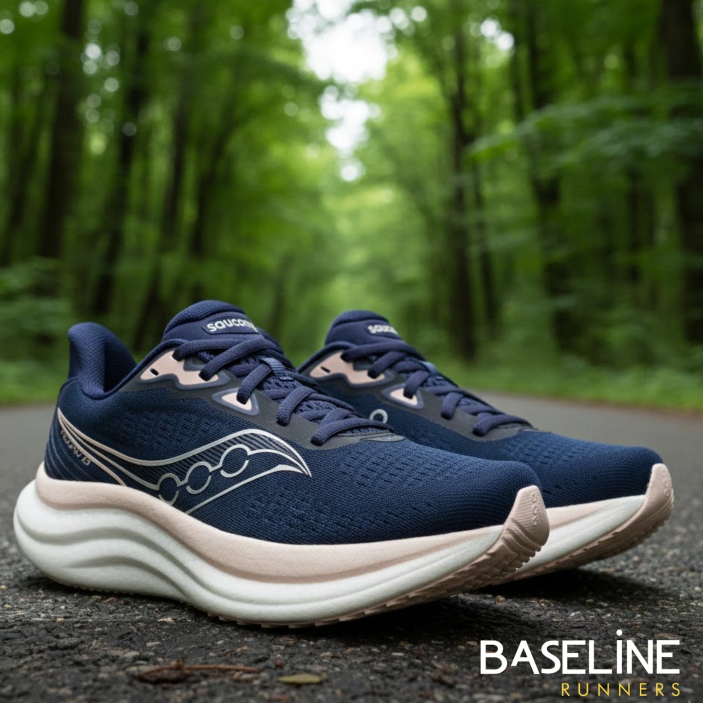 Navy running shoes with white soles on a forest path, featuring the 'Baseline Runners' brand.