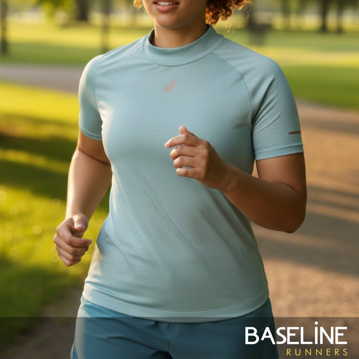Person running outdoors wearing a light blue athletic shirt with 'Baseline Runners' branding.