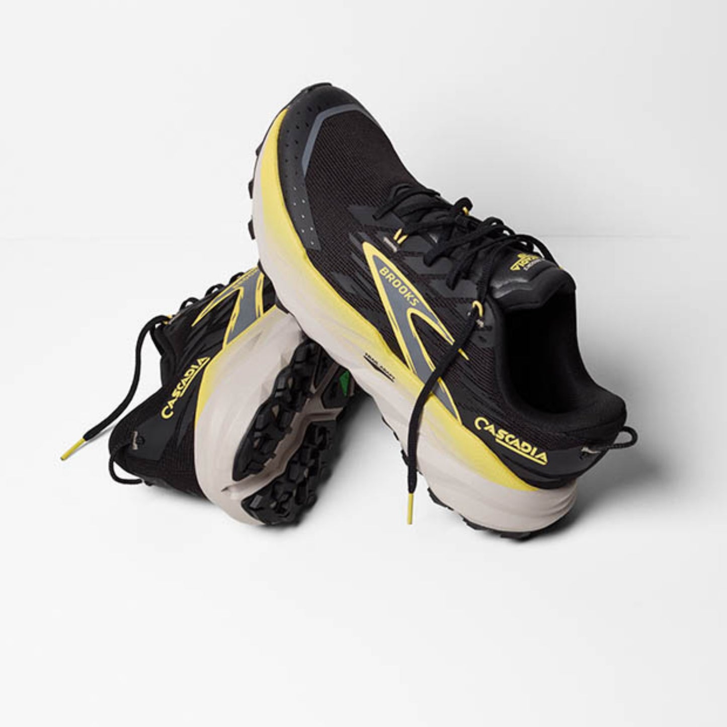 Black and yellow Brooks running shoes on a white background