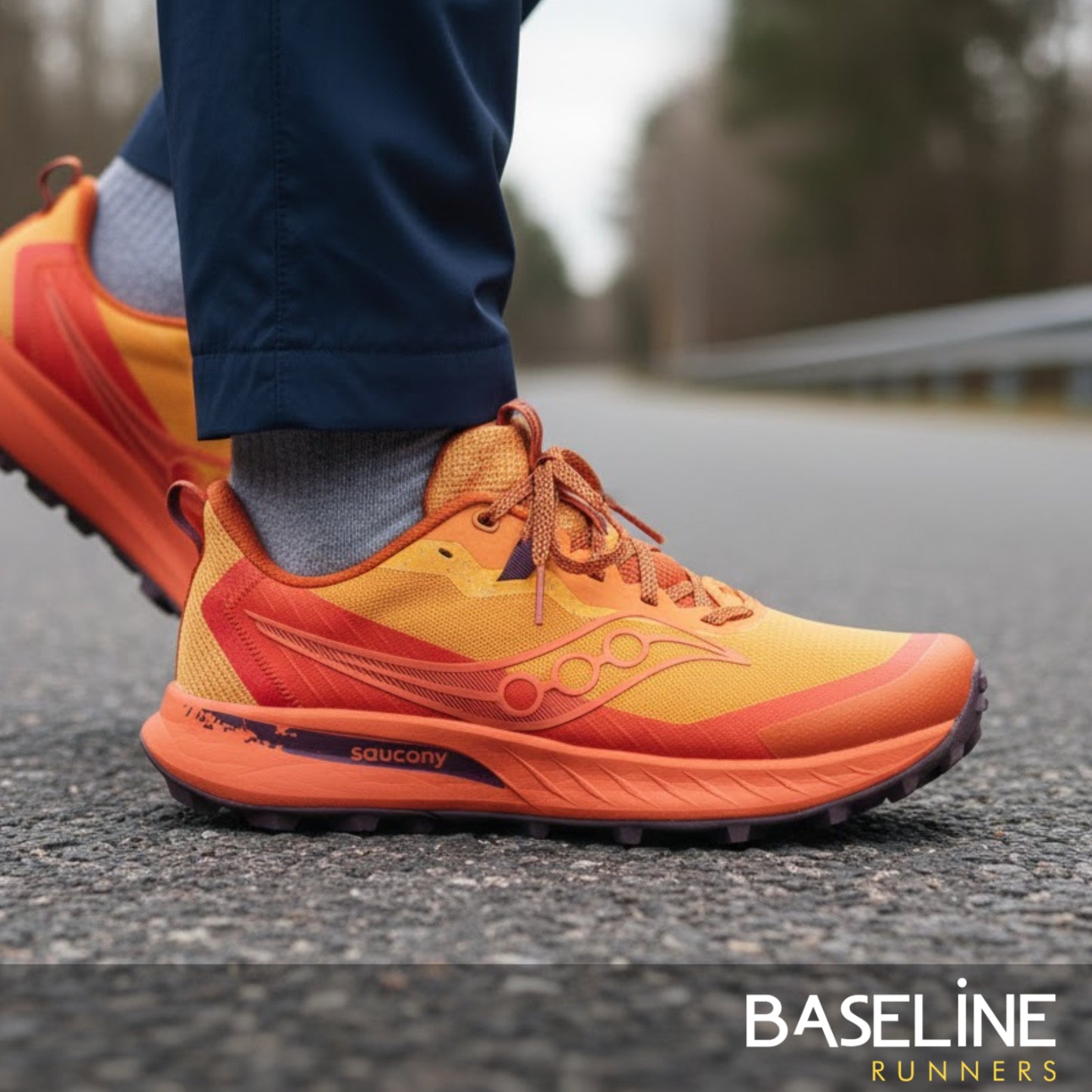 Orange and red running shoes on a road with 'Baseline Runners' branding.