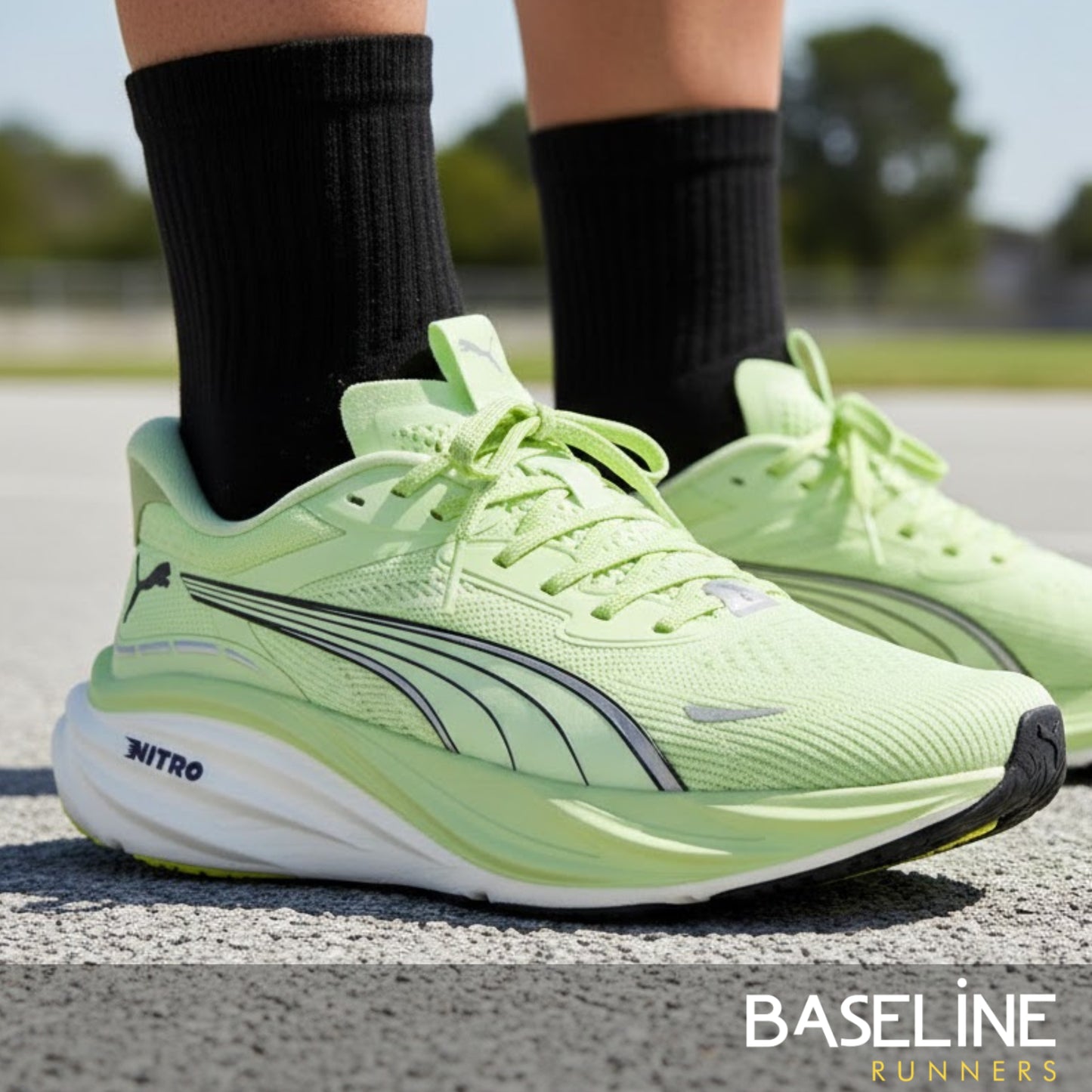 Light green running shoes with black socks on a road, featuring the Puma brand.