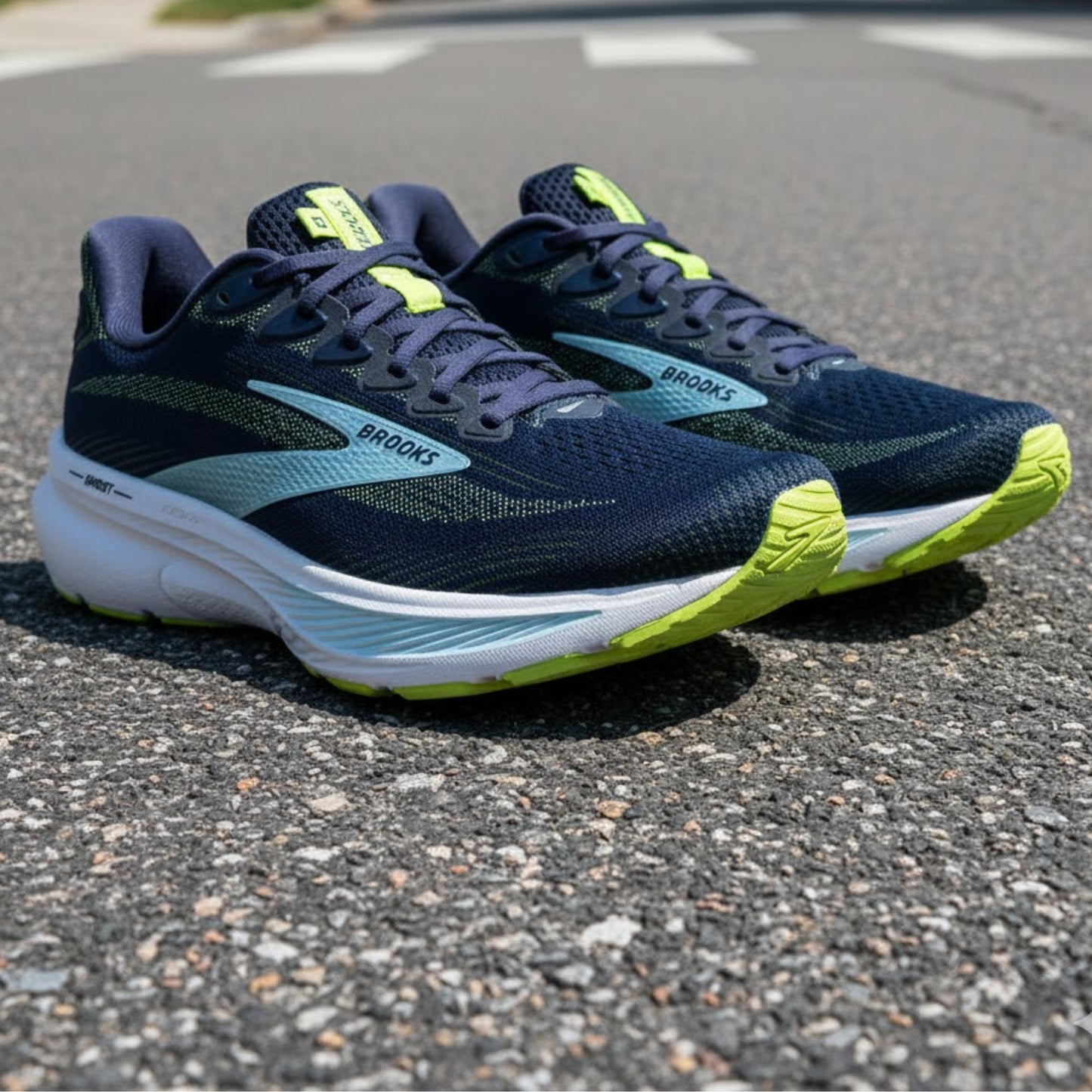 Pair of blue and green running shoes on a road