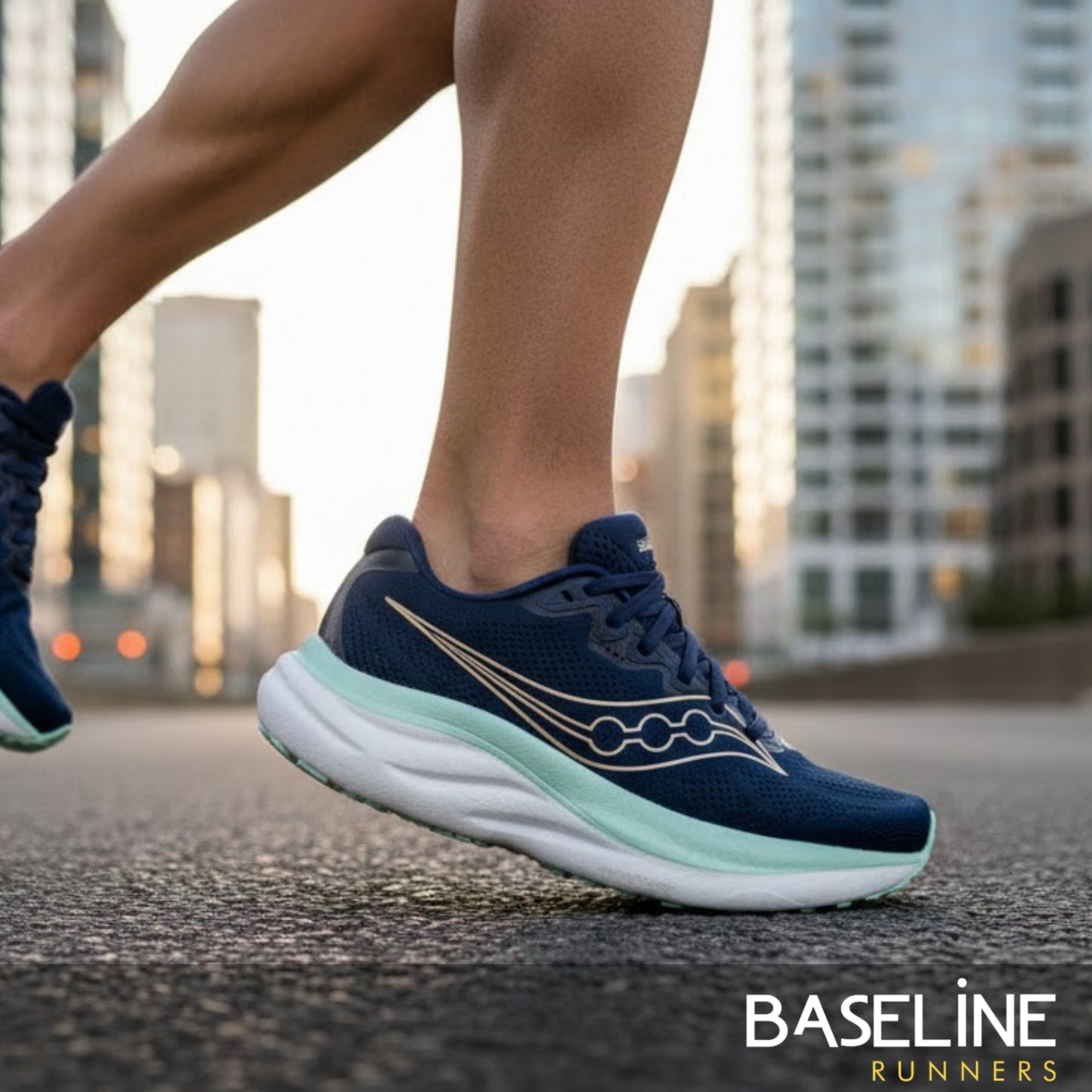 Navy Saucony running shoe with white sole on a blurred city street background, featuring the 'Baseline Runners' brand.