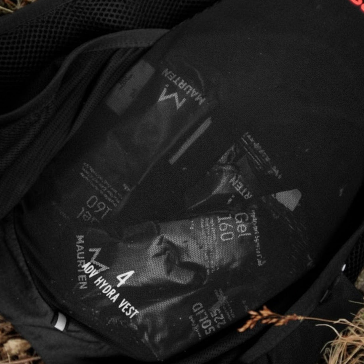 Black hydration vest with visible branding and text on a natural background