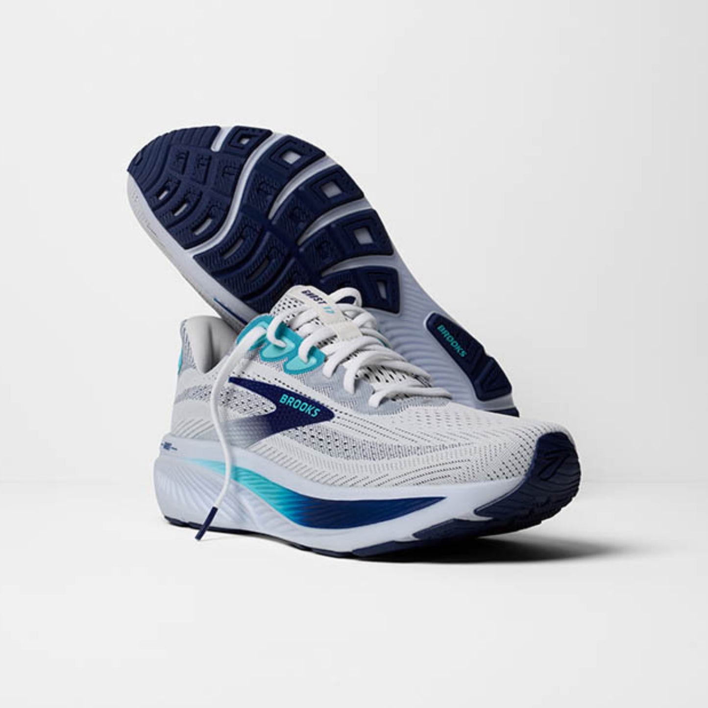 White and blue running shoe with visible Brooks logo on a light gray background