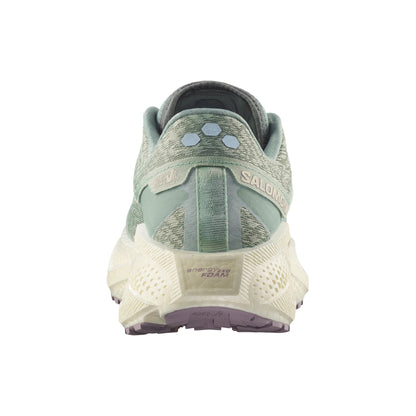 Green Salomon running shoe with white sole on a white background
