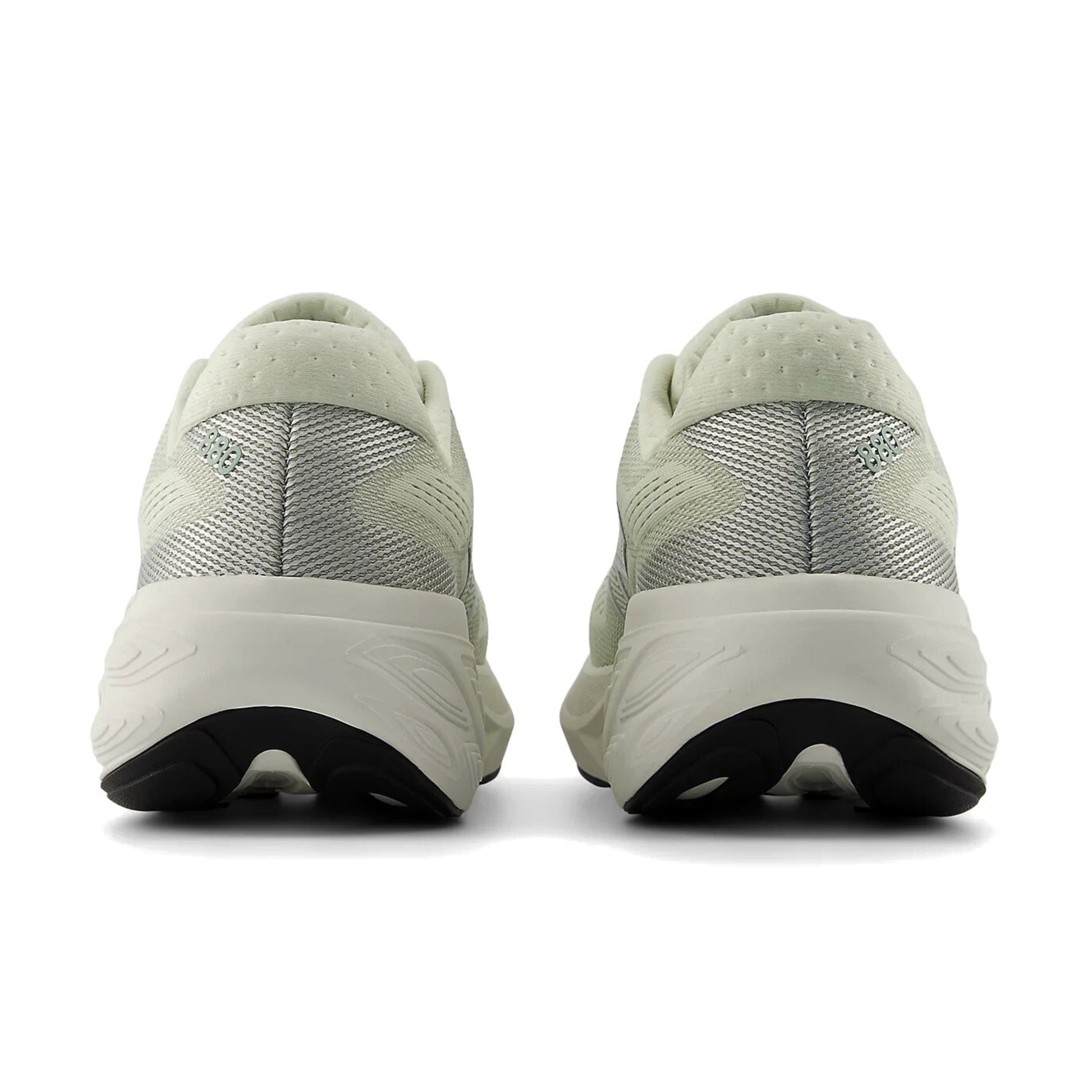 Pair of light green running shoes with black soles on a white background