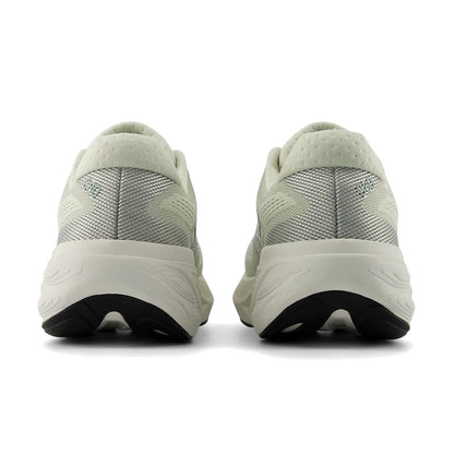 Pair of light green running shoes with black soles on a white background