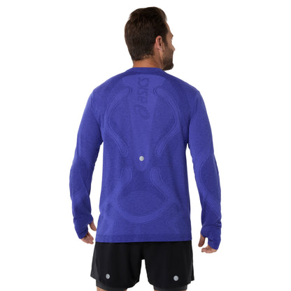 Man wearing a blue long-sleeve athletic shirt with a visible brand logo on a white background