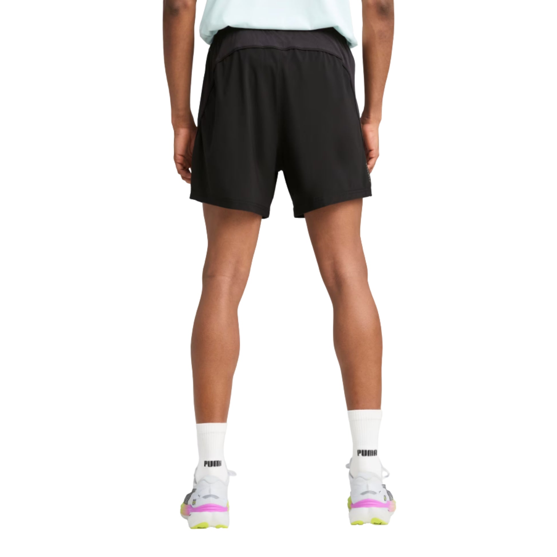 Person wearing black Puma shorts and white socks with a brand logo on a white background