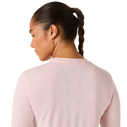Woman wearing a light pink long-sleeve athletic shirt on a white background