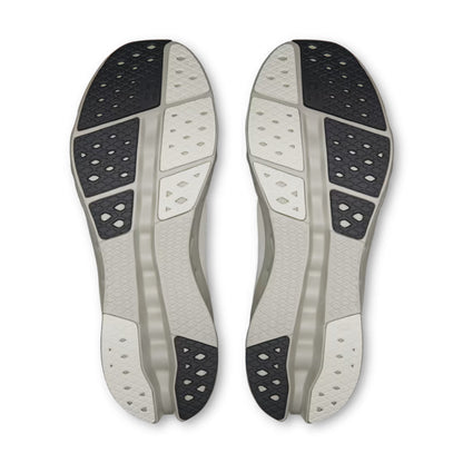 A pair of athletic shoe soles shown from the bottom, featuring a light gray and white design with black textured grip sections, photographed on a clean white background.