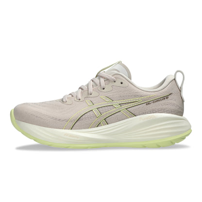 Beige running shoe with green sole on a white background