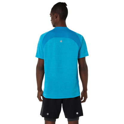 Person wearing a Asics blue shirt and black shorts on a white background