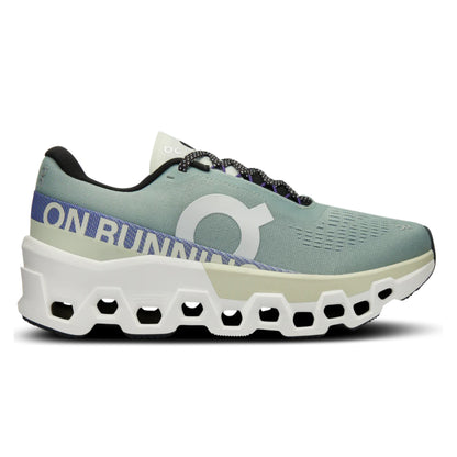 Green running shoe with white sole on a white background