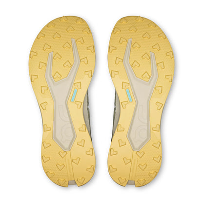 Bottom view of a yellow on shoe with patterned sole on a white background