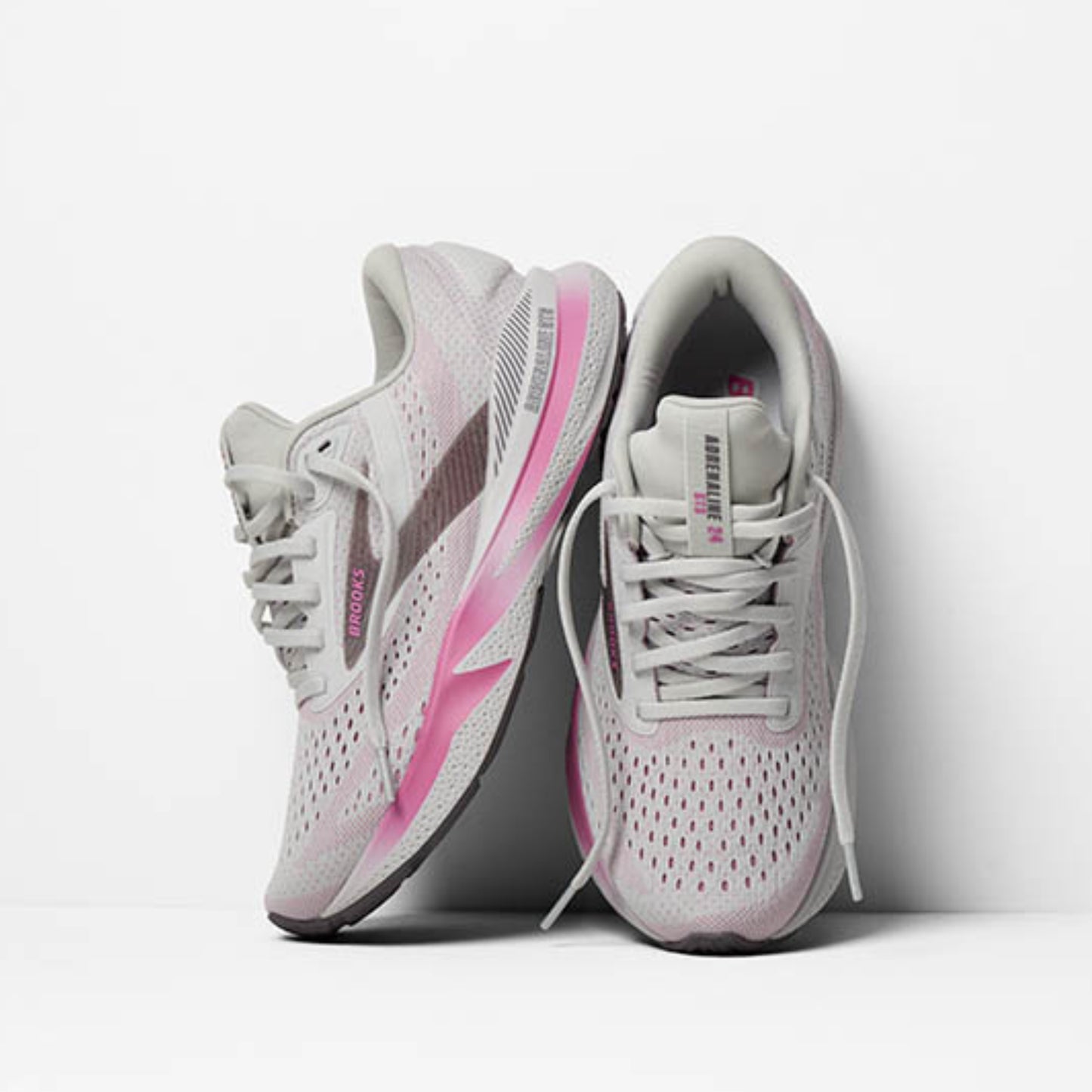 White and pink running shoes on a light gray background