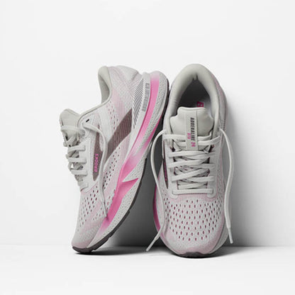 White and pink running shoes on a light gray background