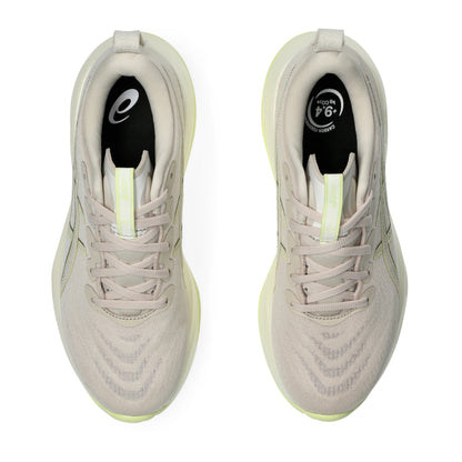 Pair of beige running shoes with black and yellow accents on a white background