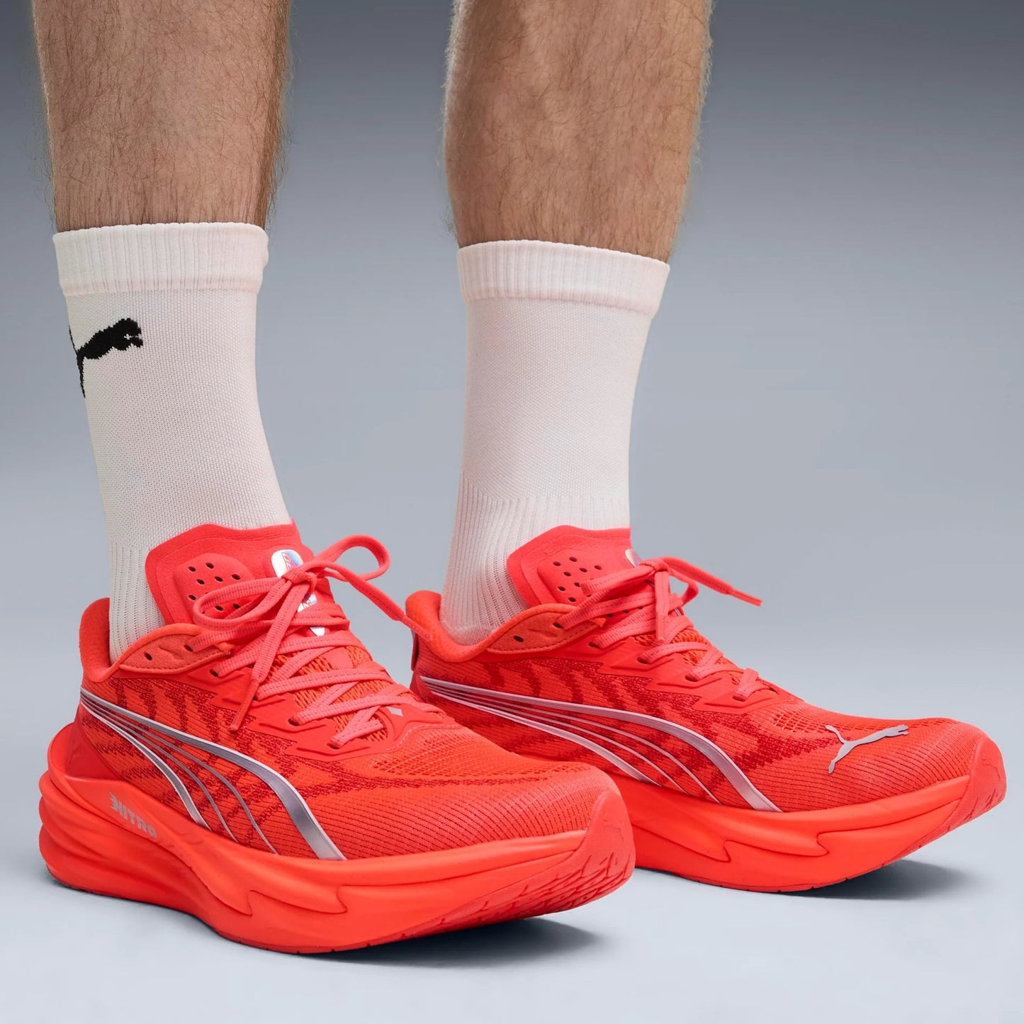 Red Puma running shoes with a visible brand logo on a gray background