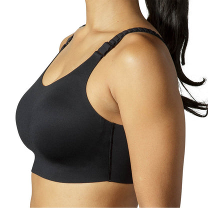 A close-up side view of a woman wearing a black wireless sports bra against a plain white background.