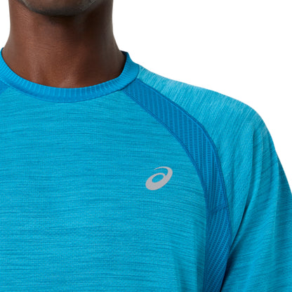 Close-up of a blue Asics shirt with a brand logo on a white background