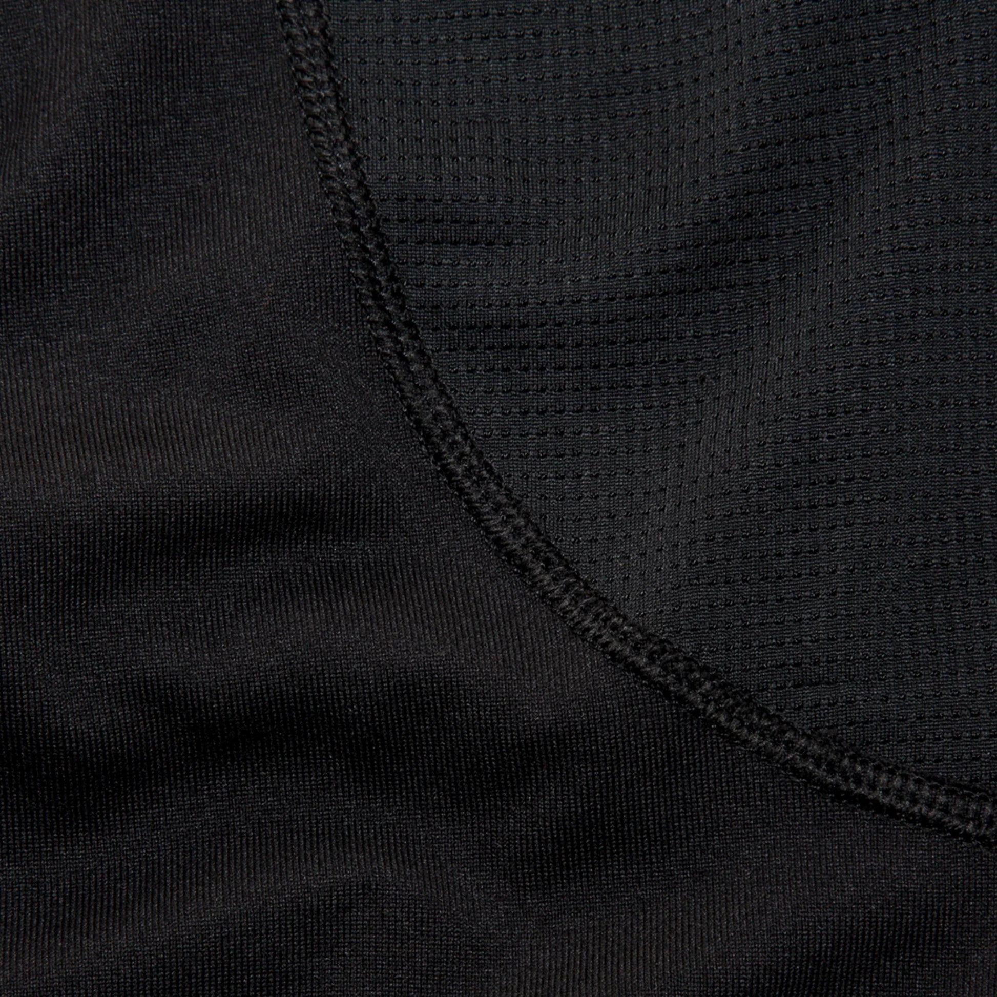 Close-up of a woman wearing a black long sleve shirt focusing on the details of the shirt