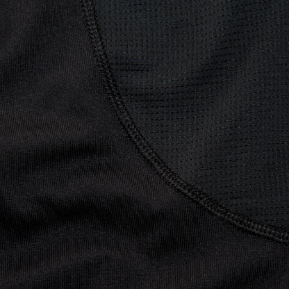 Close-up of a woman wearing a black long sleve shirt focusing on the details of the shirt