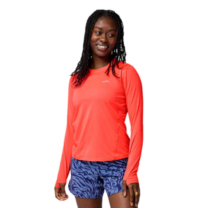 Woman wearing a orange long sleeve shirt on a white background