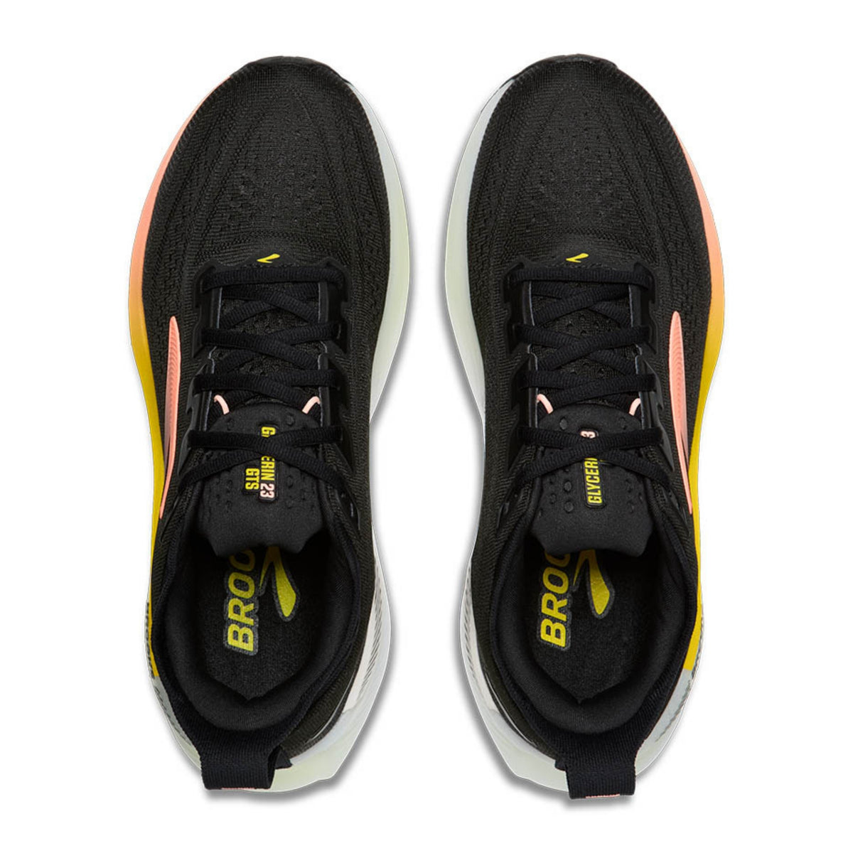 A pair of Brooks running shoes shown from a top-down view on a solid white background. The shoes feature a black mesh upper with a white midsole, accented by yellow and pink details.
