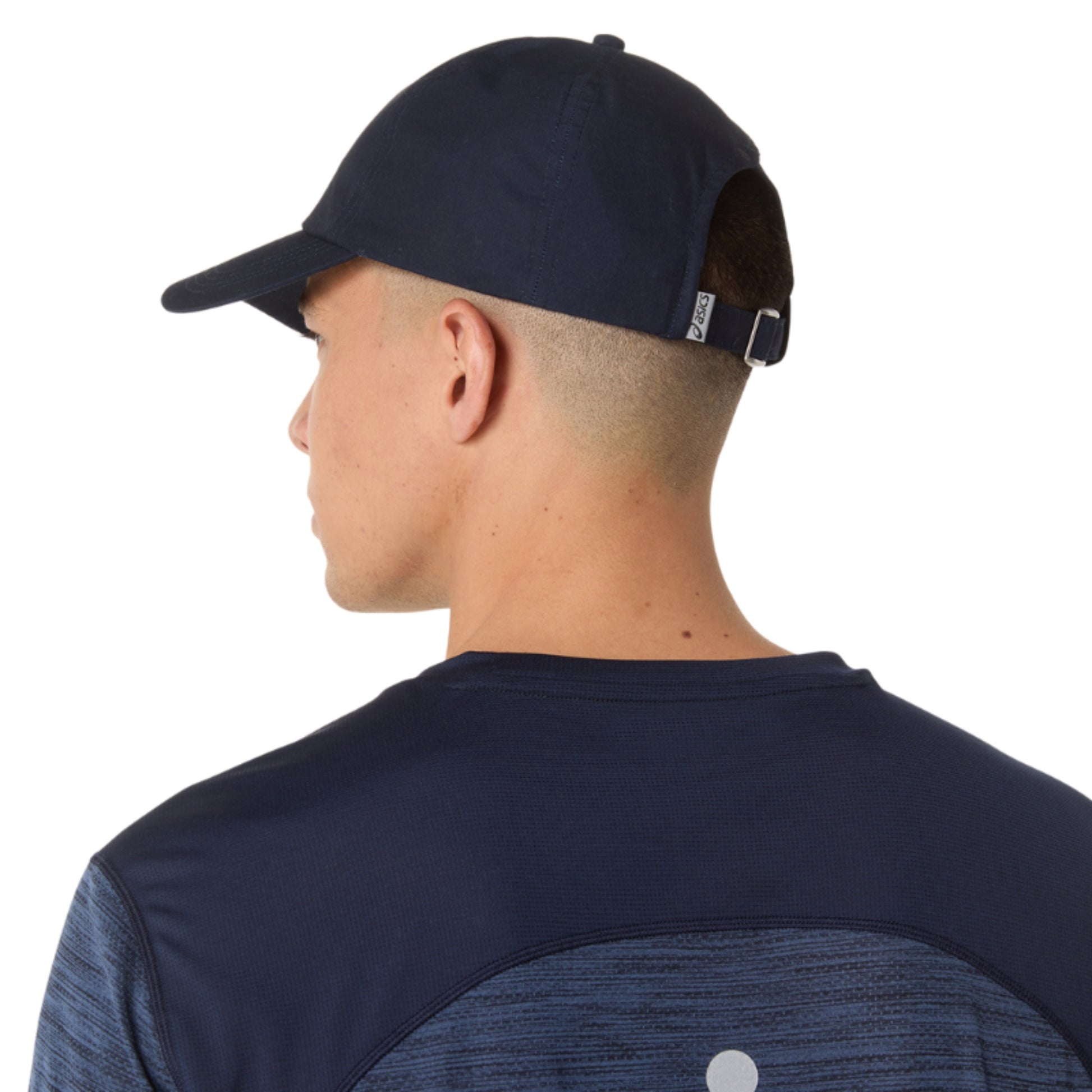 Person wearing a navy cap and shirt on a white background