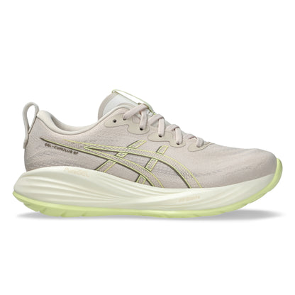 Beige running shoe with green sole on a white background