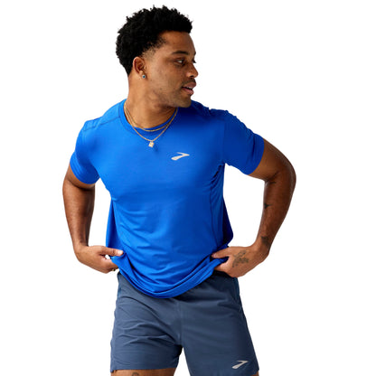 Man wearing a blue athletic shirt and shorts with a brand logo on a white background