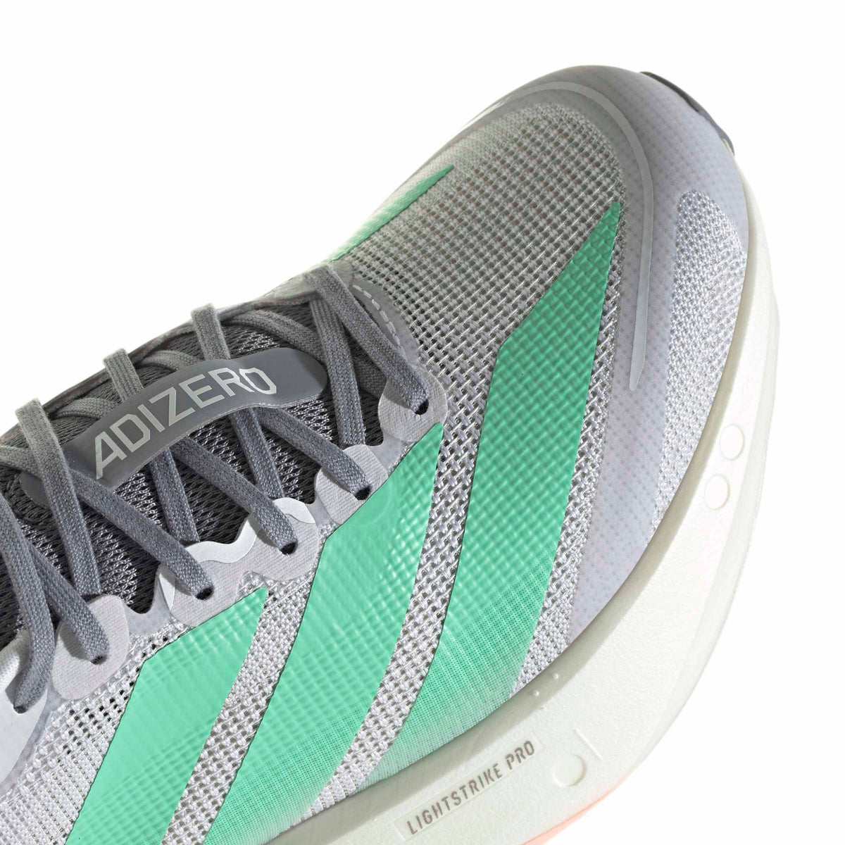 Close-up of an Adidas Adizero running shoe in gray and mint green, showing the textured mesh upper, gray laces, and part of the white Lightstrike Pro midsole.