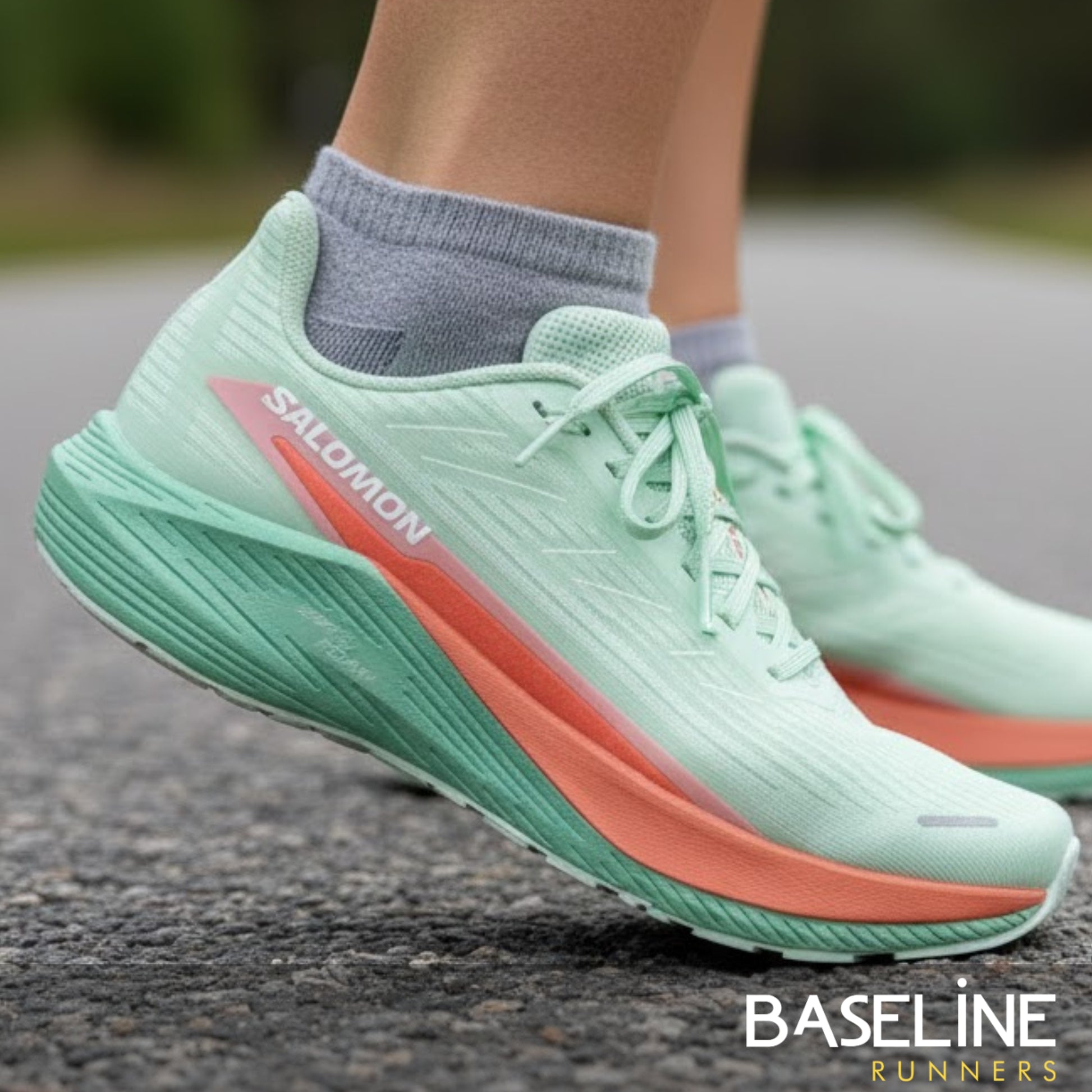 Salomon running shoes on a road with 'Baseline Runners' branding.