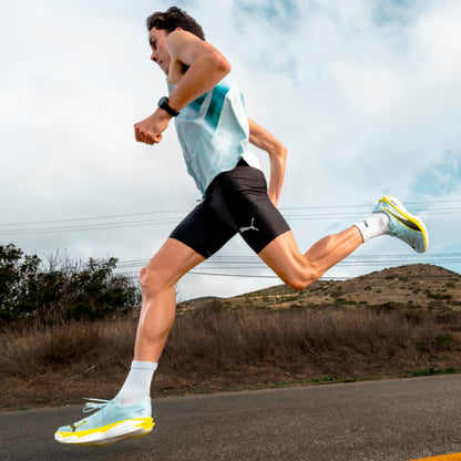 Person running outdoors on a road with a clear sky