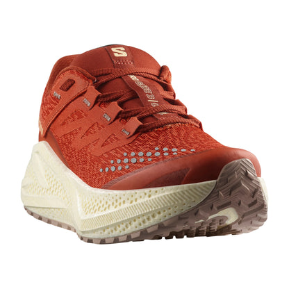 Red Salomon running shoe with white sole on a white background