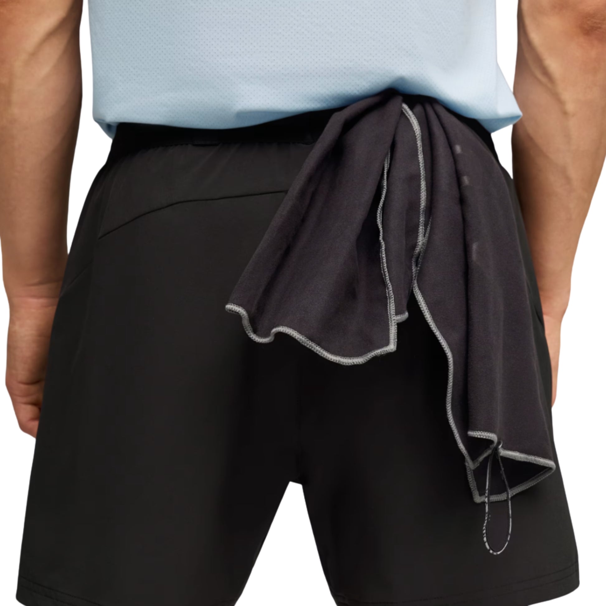 Person wearing black Puma shorts with a gray towel draped over the shoulder on a white background