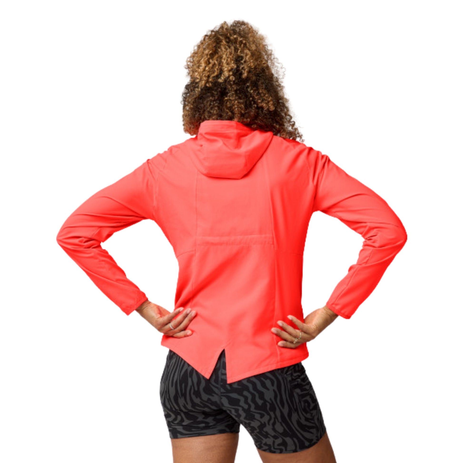 Woman wearing a orange jacket with a Brooks logo on a white background