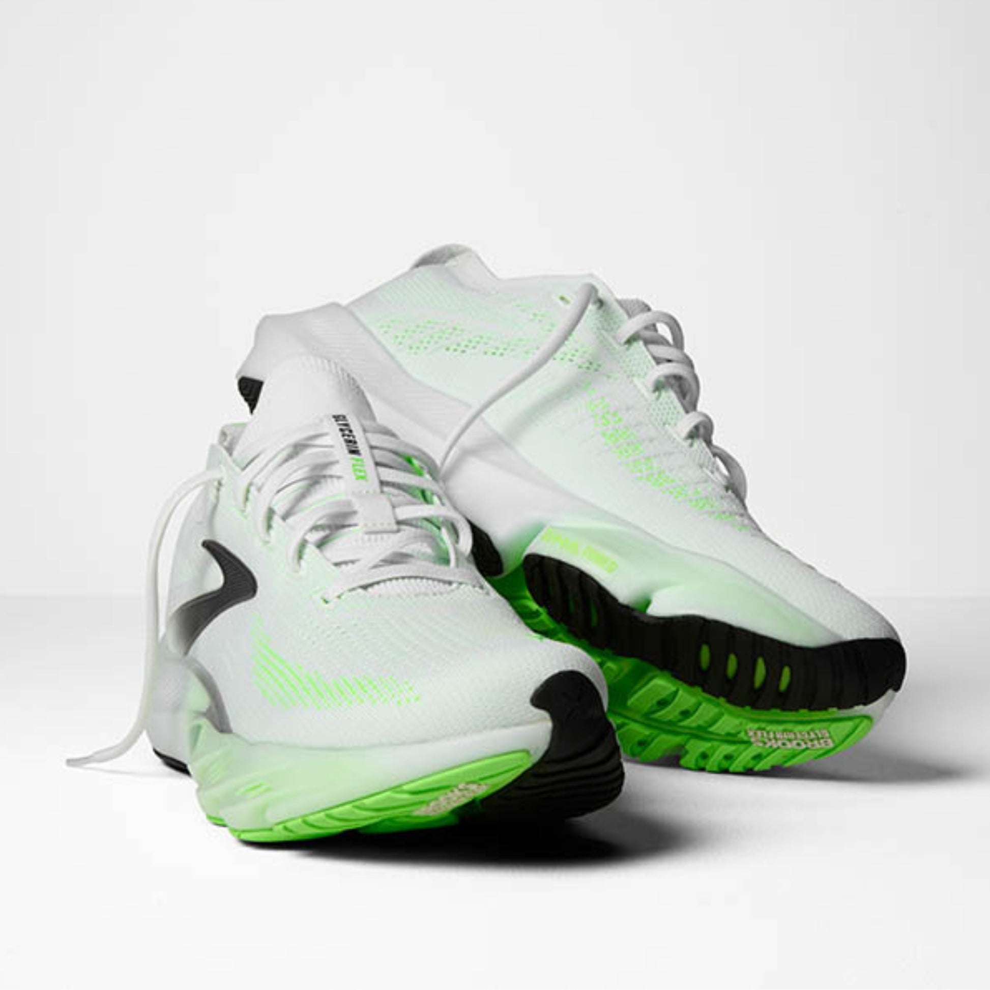 White Brooks running shoes with green accents on a light gray background