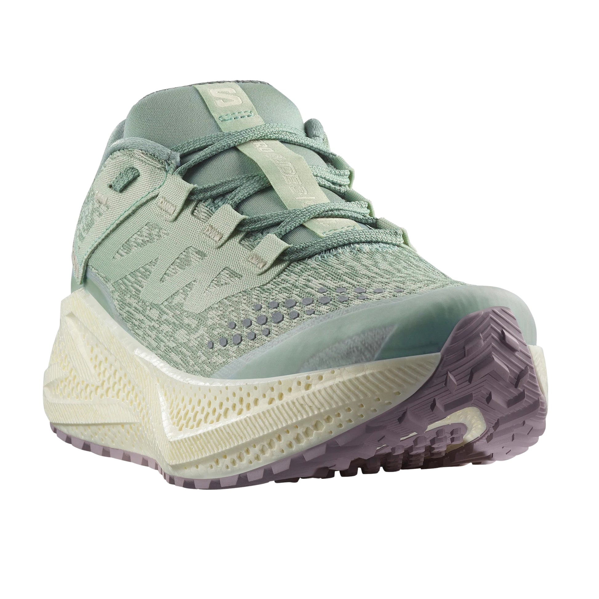 Green Salomon running shoe with a white sole on a white background