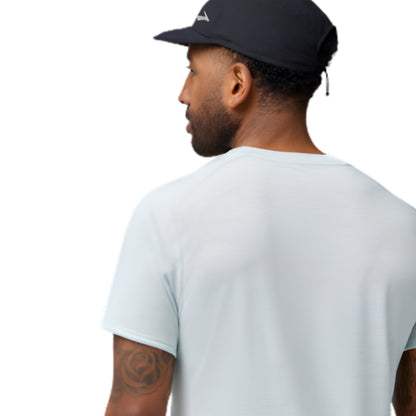 Man wearing a light blue t-shirt and dark cap on a white background