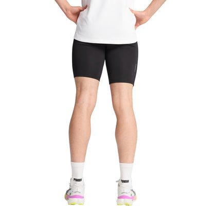 Person wearing black Puma tights on a white background