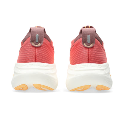 Pair of orange running shoes with white soles and orange accents on a white background