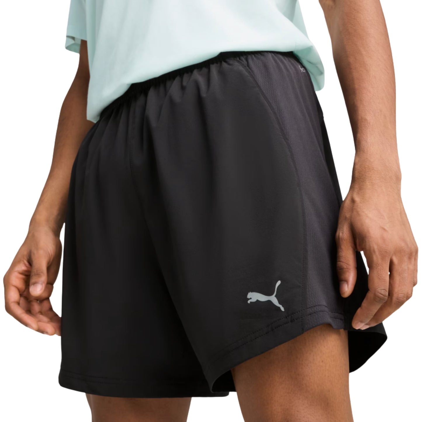 Black Puma shorts with a Puma logo worn by a person on a white background
