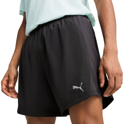 Black Puma shorts with a Puma logo worn by a person on a white background