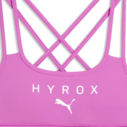 Pink sports bra with criss-cross straps and 'HYROX' branding on a white background
