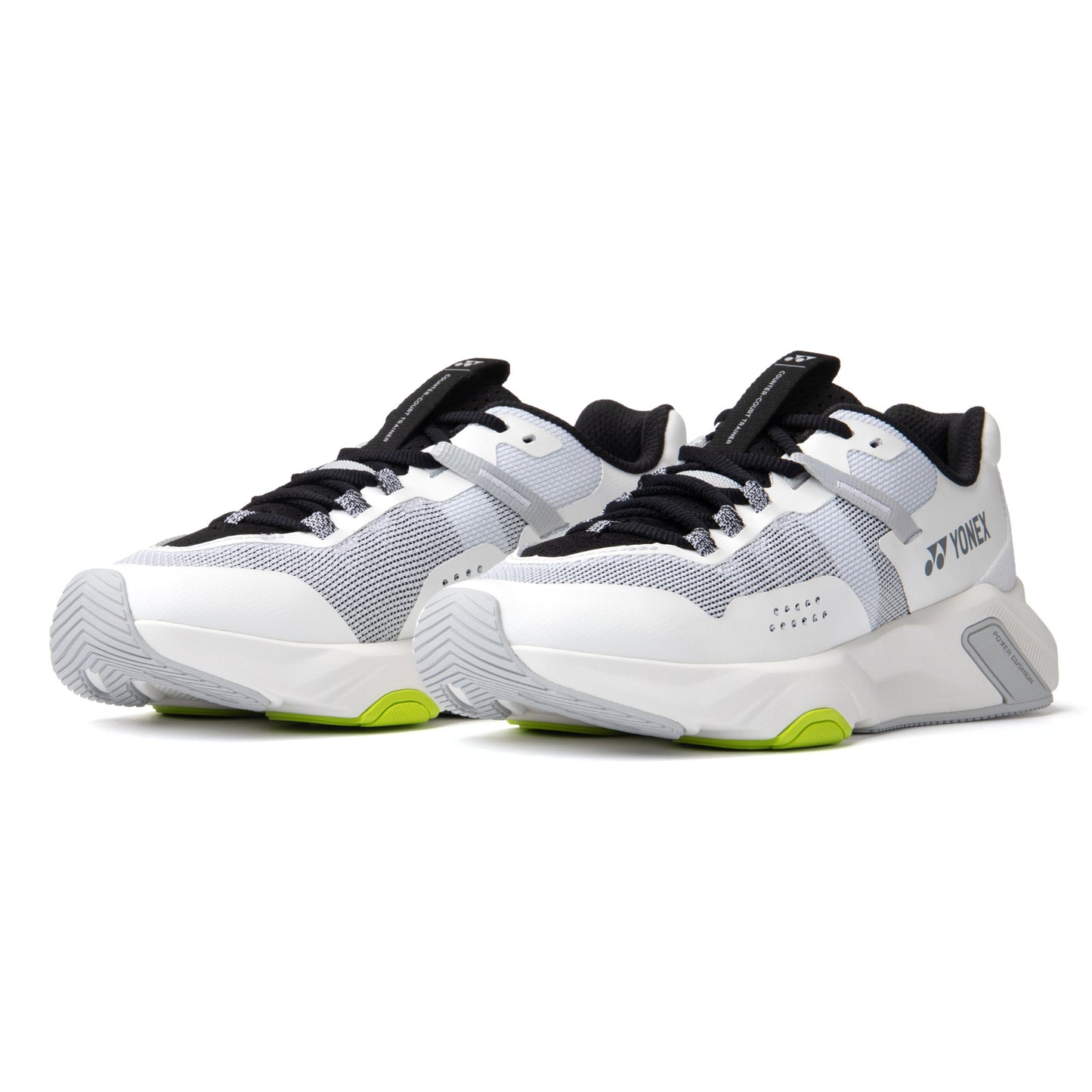 White and black Yonex running shoes with green accents on a white background